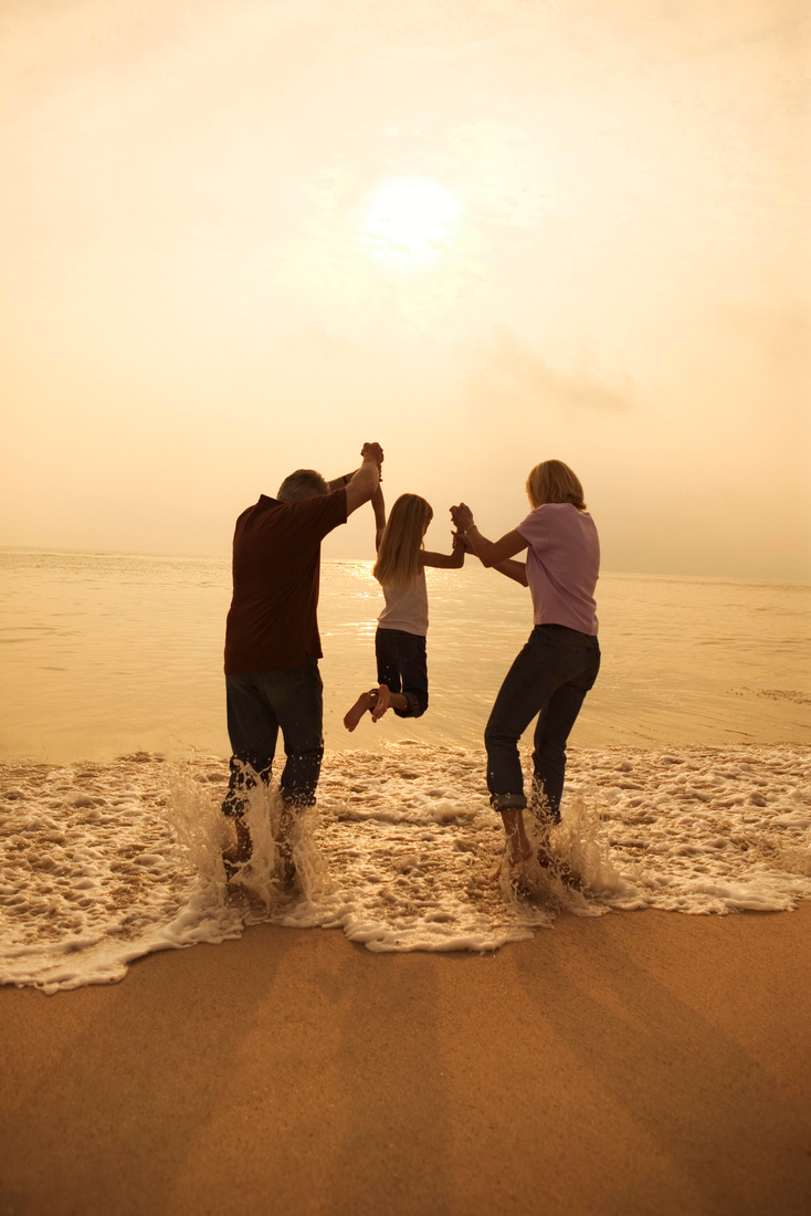 Family on beach playing in surf